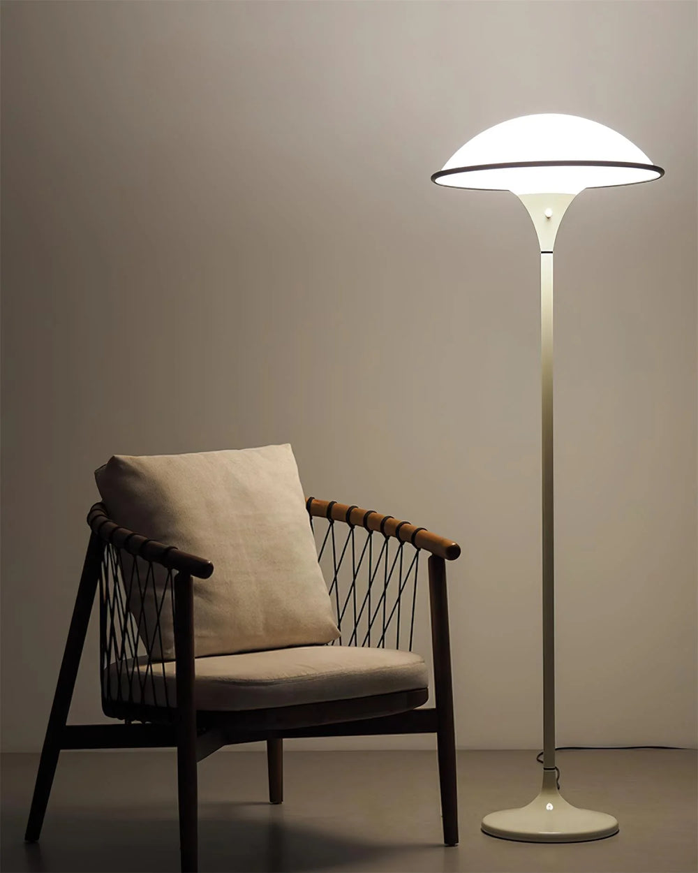 Modern Home Floor Lamp next to a stylish chair in a minimalistic setting, providing soft ambient light.