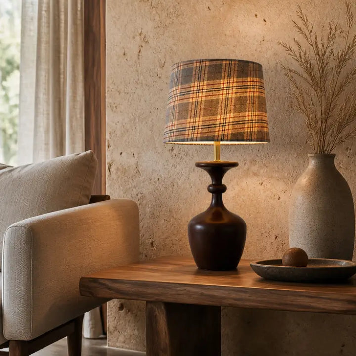 Rustic accent table lamp with checkered drum shade resting on a rough stone texture wall side table