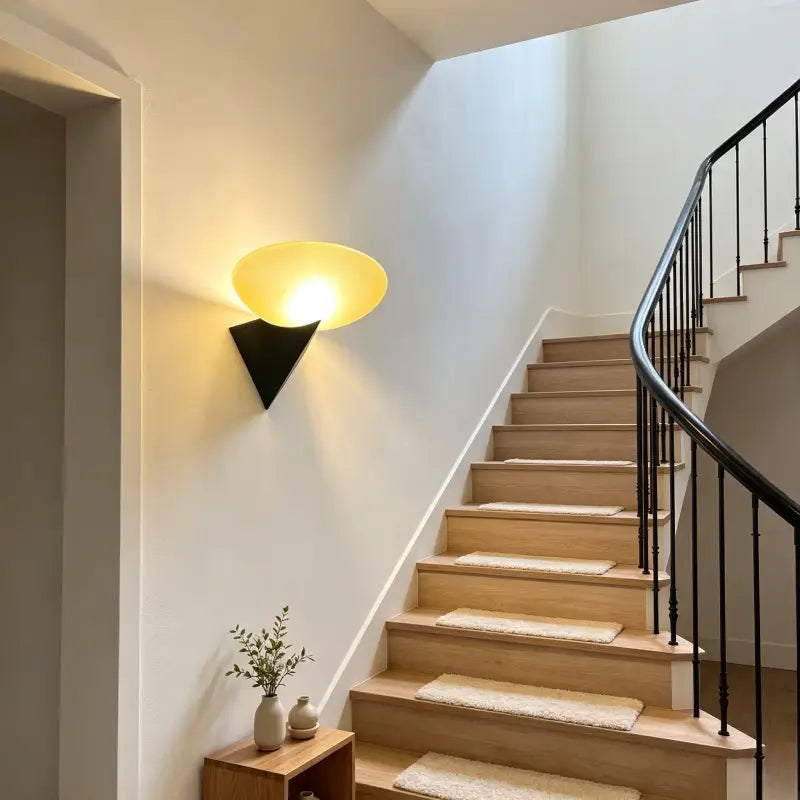 Bauhaus Retro Wall Lamp with frosted amber glass shade, mounted on hallway wall providing ambient lighting for wooden staircase area