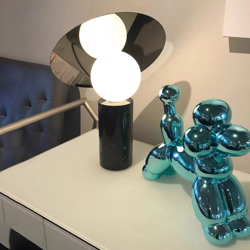 Bola_Disc_Table_Lamp with a glass lampshade is on the table