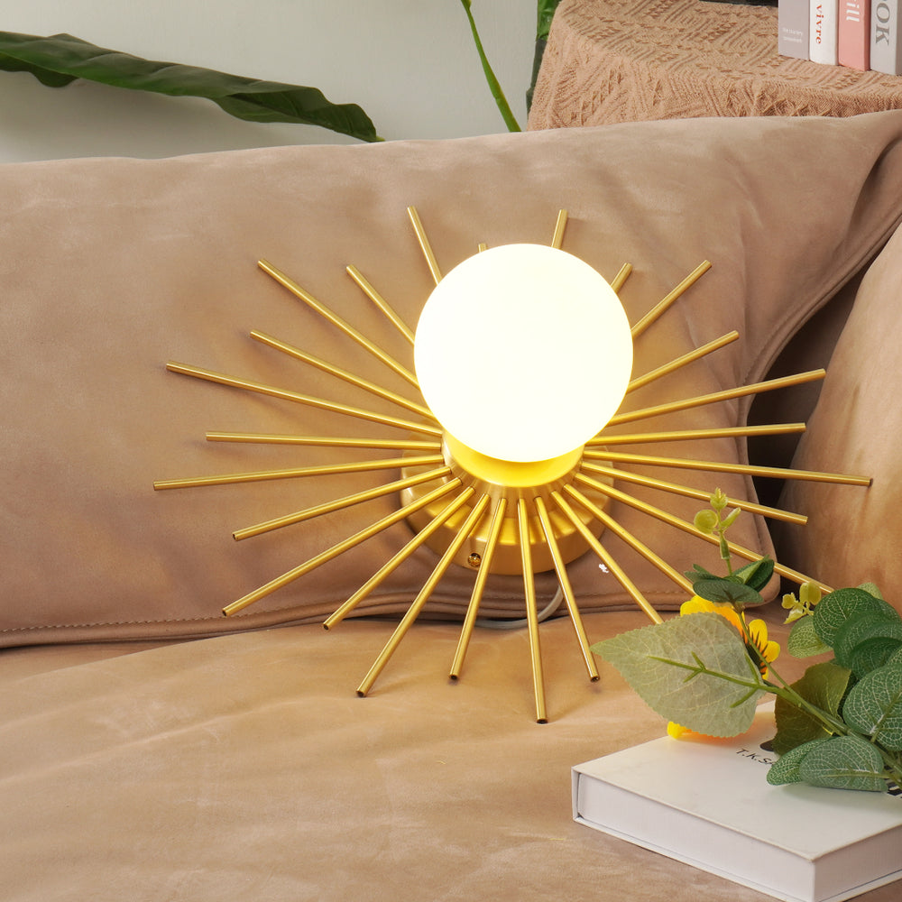 Brass Sunburst Ceiling Lamp with a round white light and golden rays on a soft beige couch.