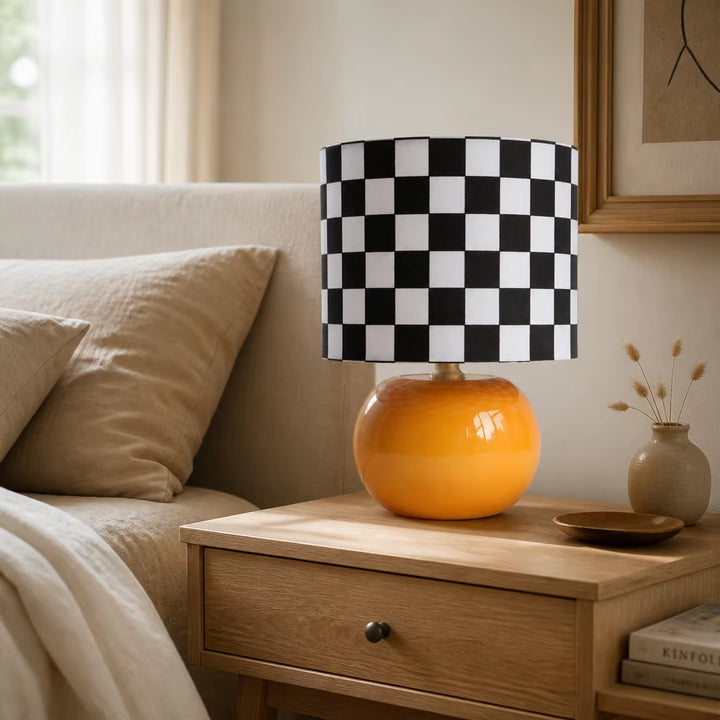 Danish modern orange base checkerboard accent lamp on travertine console table in bright sunlit home reading corner