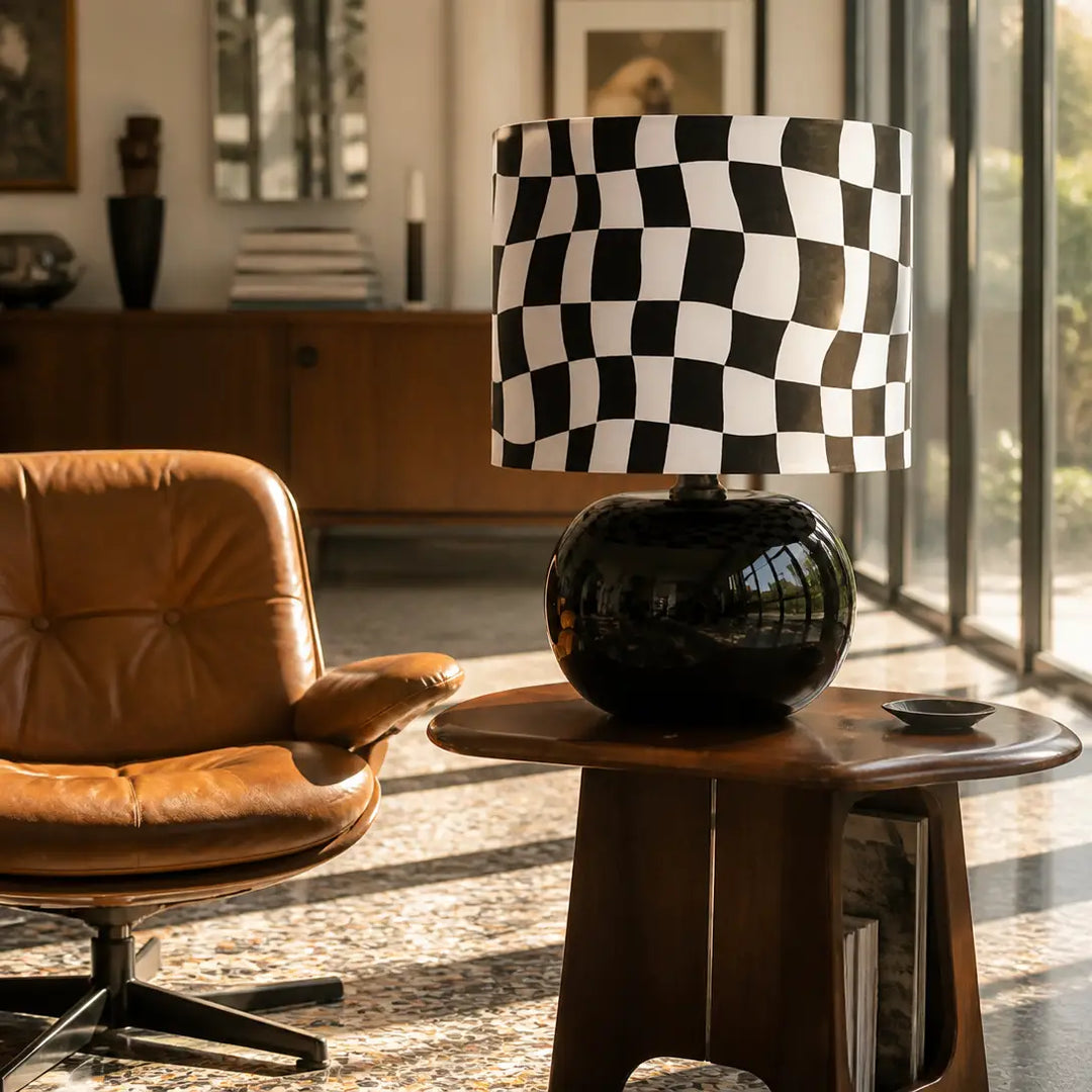 70s retro psychedelic wavy checkered table lamp with black glossy base on walnut side table next to vintage leather accent chair