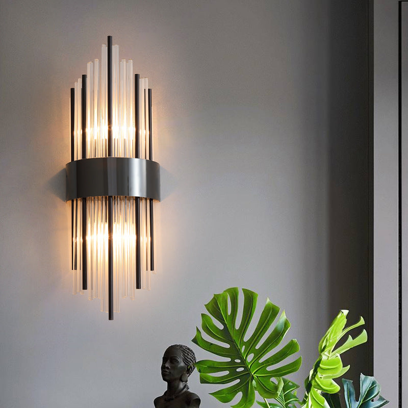 Elegant Crystal Wall Sconce illuminating a wall with a modern design, surrounded by greenery and a decorative statue.