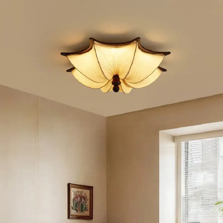 Modern Luvina Ceiling Lamp with pleated fabric shade and walnut-finish frame illuminating a cozy room.