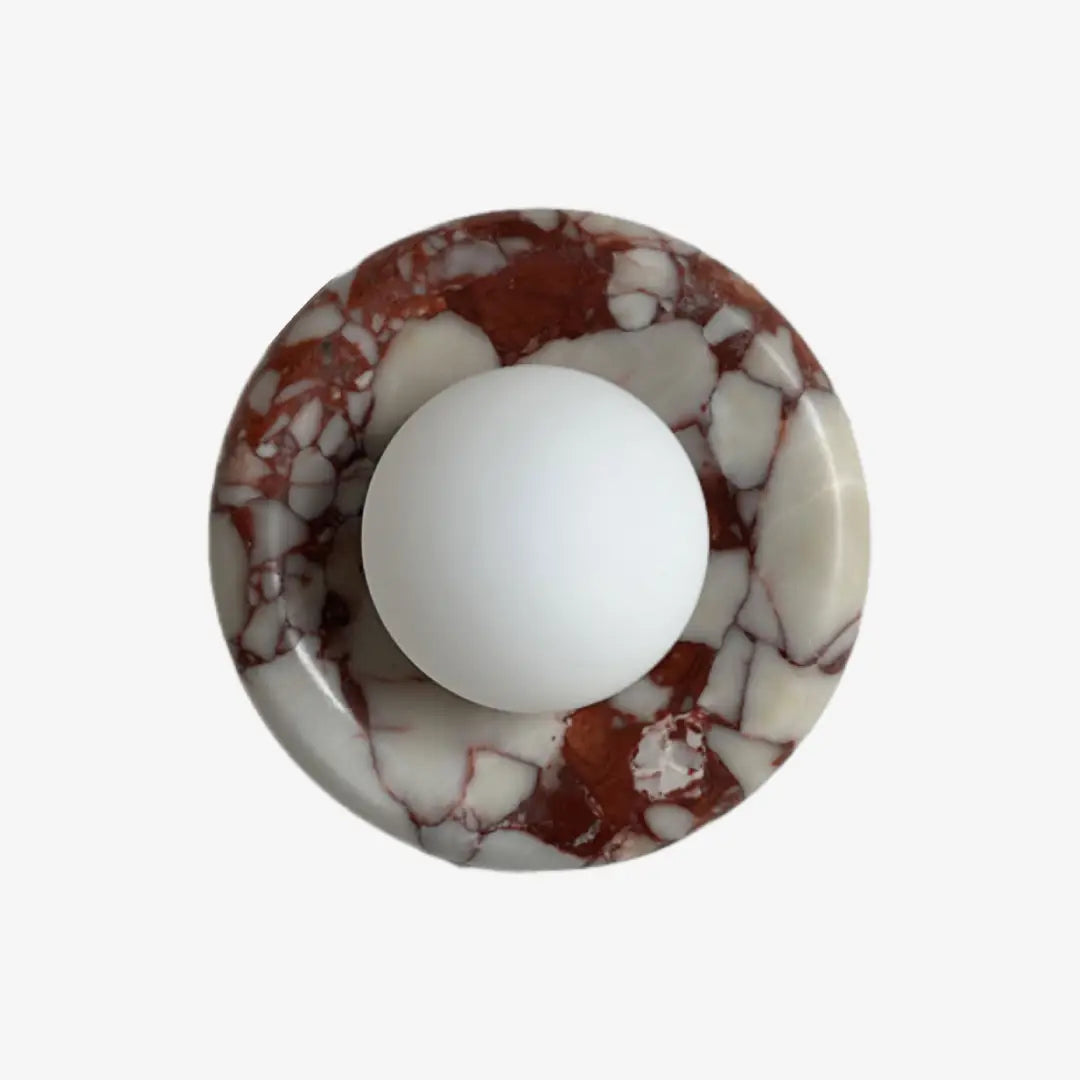 Modern Round Marble LED Wall Lamp with red breccia marble base and frosted glass globe on plain white background