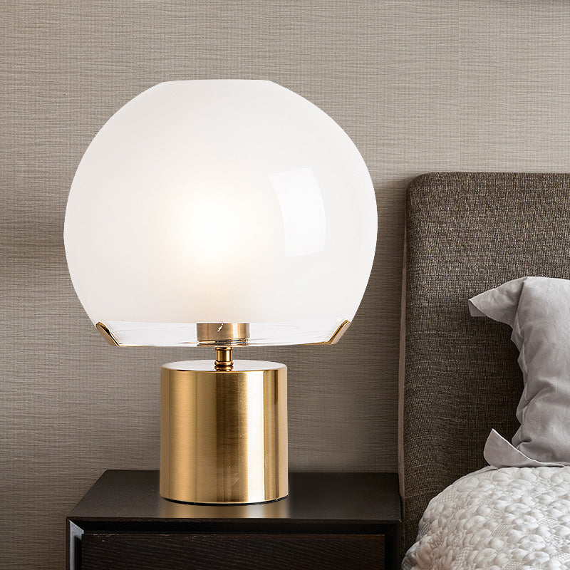 Nordic Round Table Lamp on a nightstand next to a cozy bed, featuring a sleek minimalistic design.