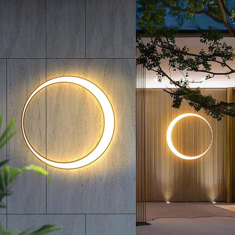 Outdoor Crescent Wall Light with glowing circular LED ring, creating depth between foreground wall and background architectural space with warm ambient lighting