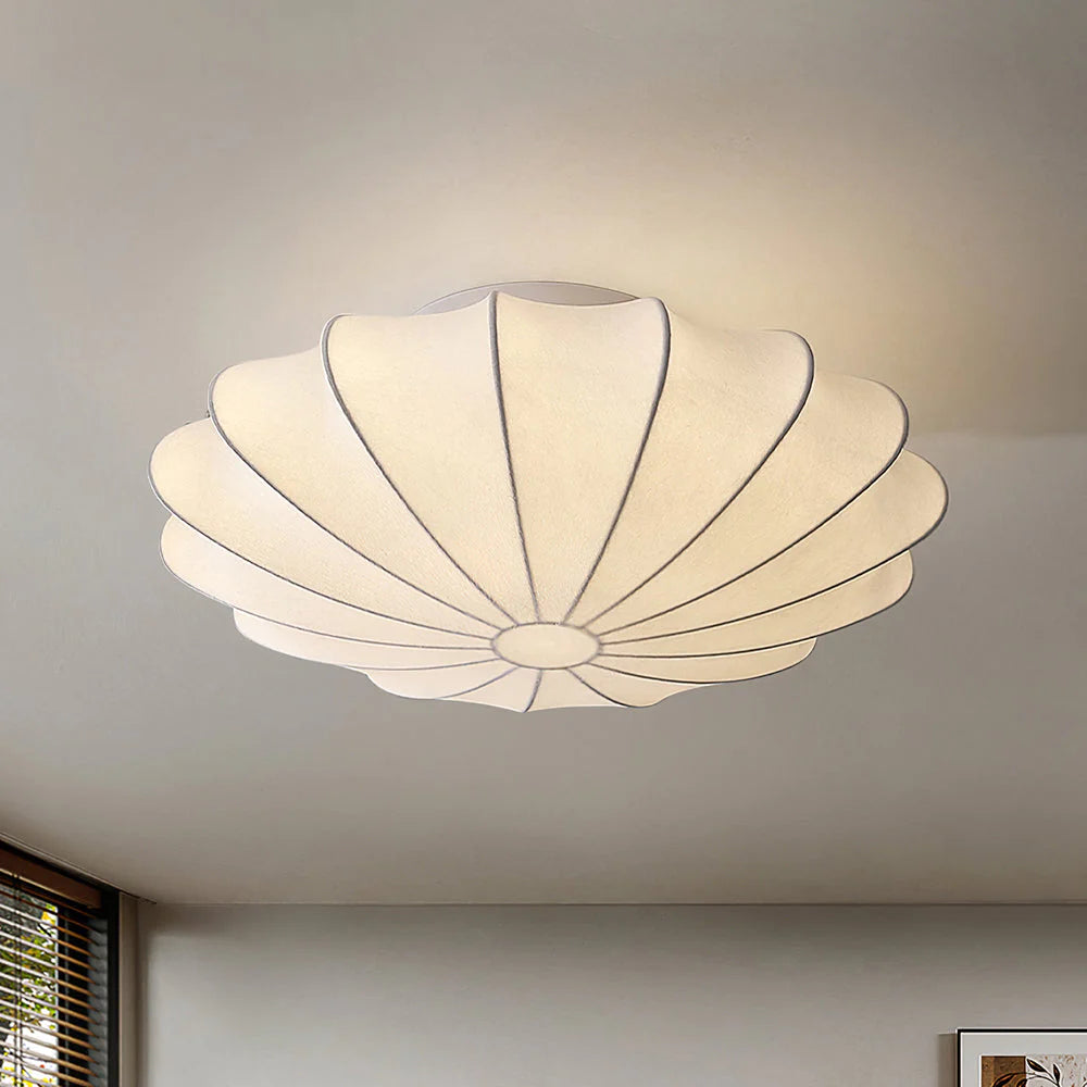 Pleated fabric flush mount ceiling light in a shell-shaped design with soft warm illumination