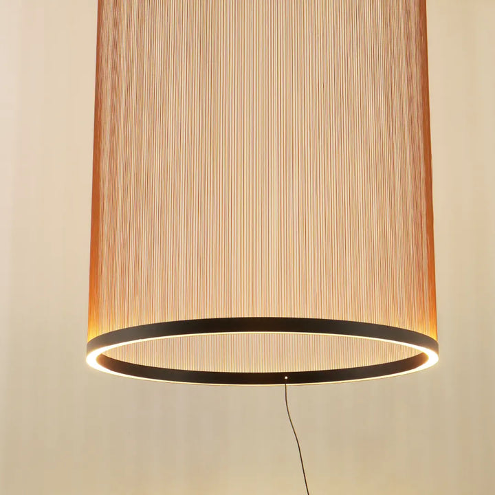 Spanish Cylinder Chandelier, tall cylindrical pendant lamp with vertical fabric‑string shade and glowing LED ring, warm ambient lighting for modern living room