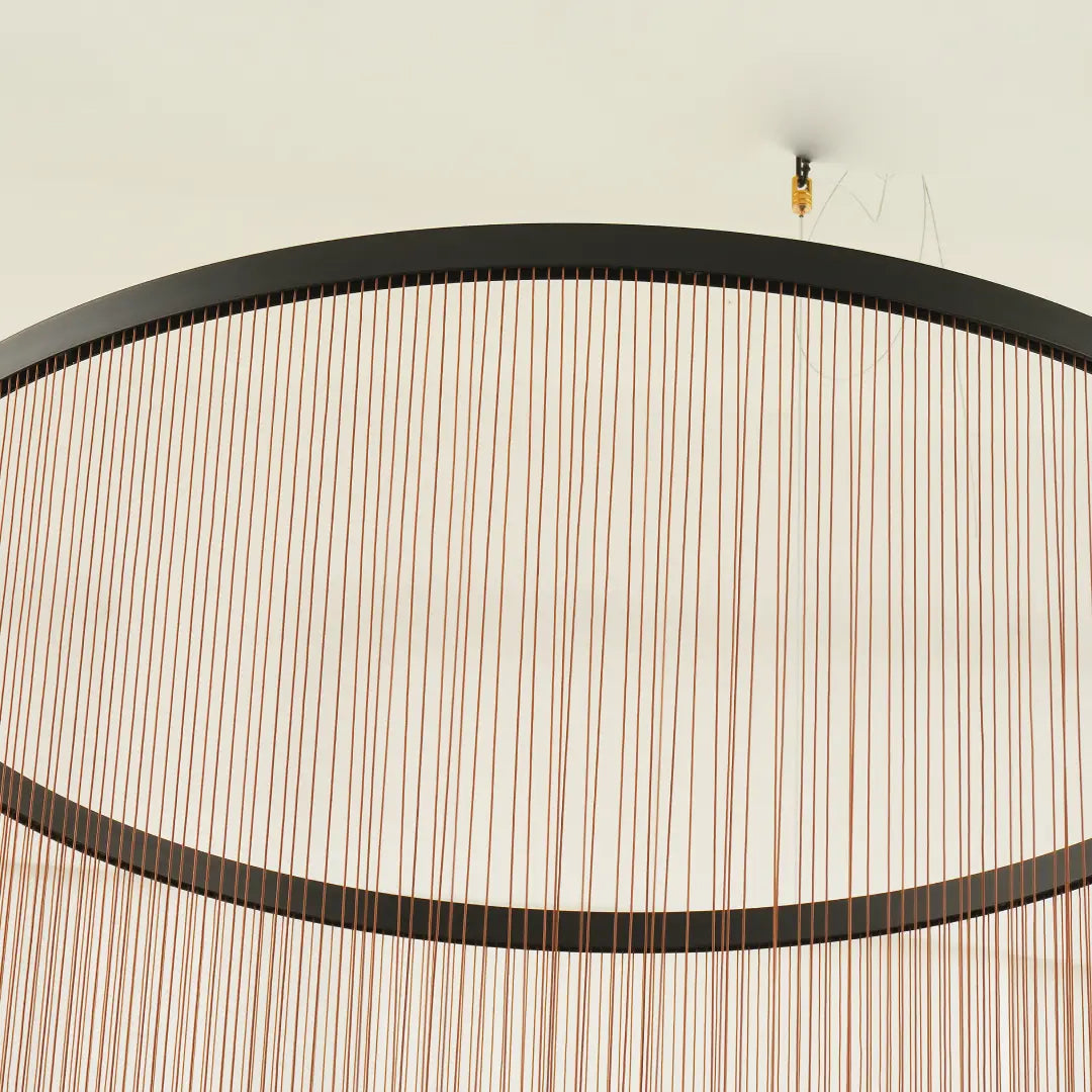Spanish Cylinder Chandelier, top‑angle close‑up of ceiling suspension fitting, black circular metal rim and fine vertical string curtain lampshade