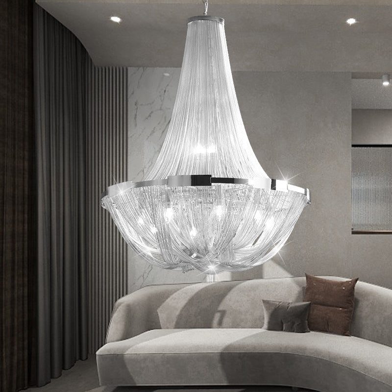 Tassel pendant light with cascading aluminum chains above a sofa in a modern living room with textured walls and soft lighting