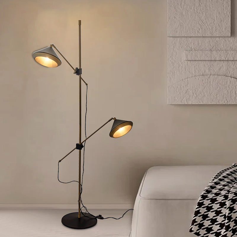 Trumpet Double-Headed Floor Lamp featuring an antique bronze finish and two adjustable lamp heads in a modern living space.