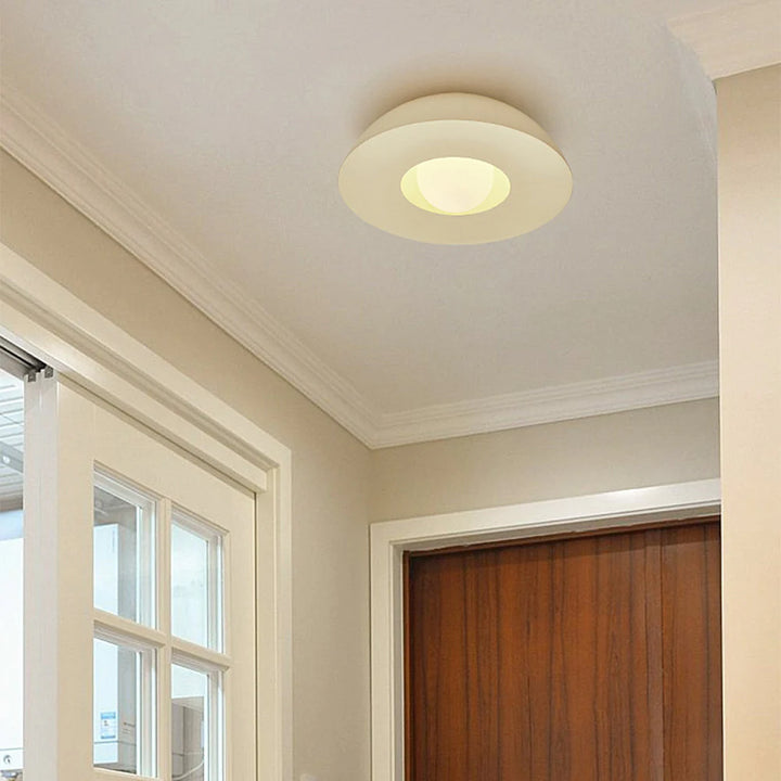 Two ceiling lights made of resin and glass are placed in the entryway
