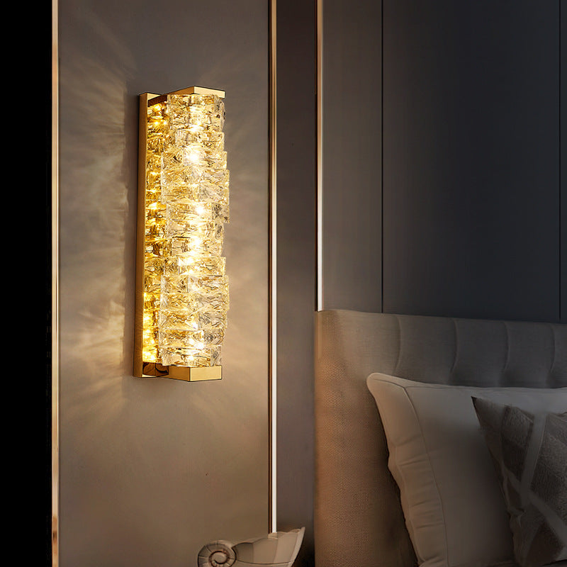 Vertical Crystal Glow Sconce illuminating a modern bedroom wall with warm light and elegant design.