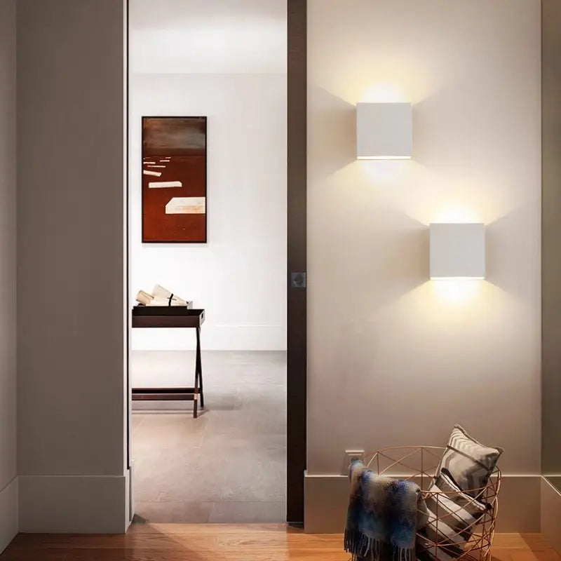 Pair of white Volex square wall lamps lit on hallway wall creating symmetrical warm light for modern home entryway and corridor interior styling