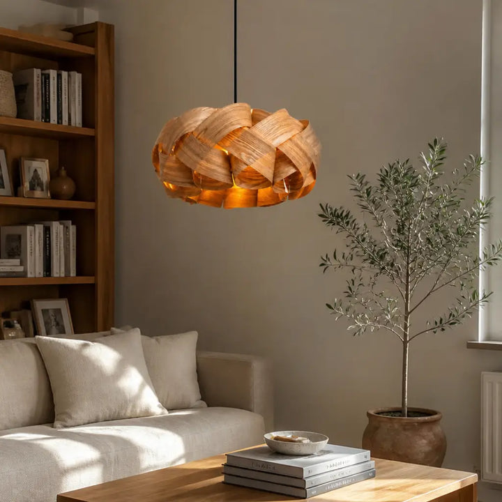 Curved wood strip pendant light casting ambient warm light over wooden dining table