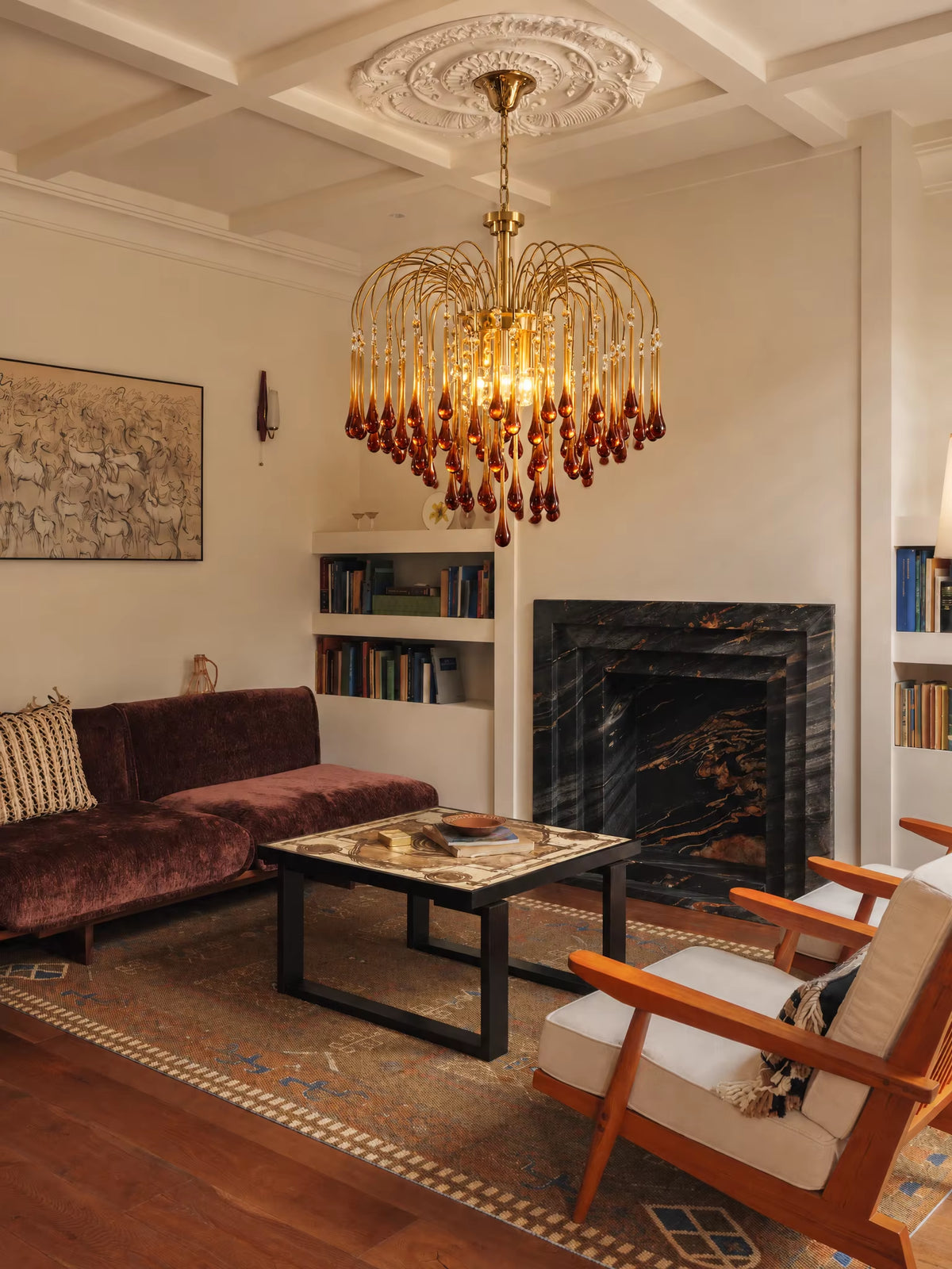 Vertical view of warm glowing brass and cognac glass teardrop chandelier suspended from carved ceiling rosette in a sophisticated vintage living space