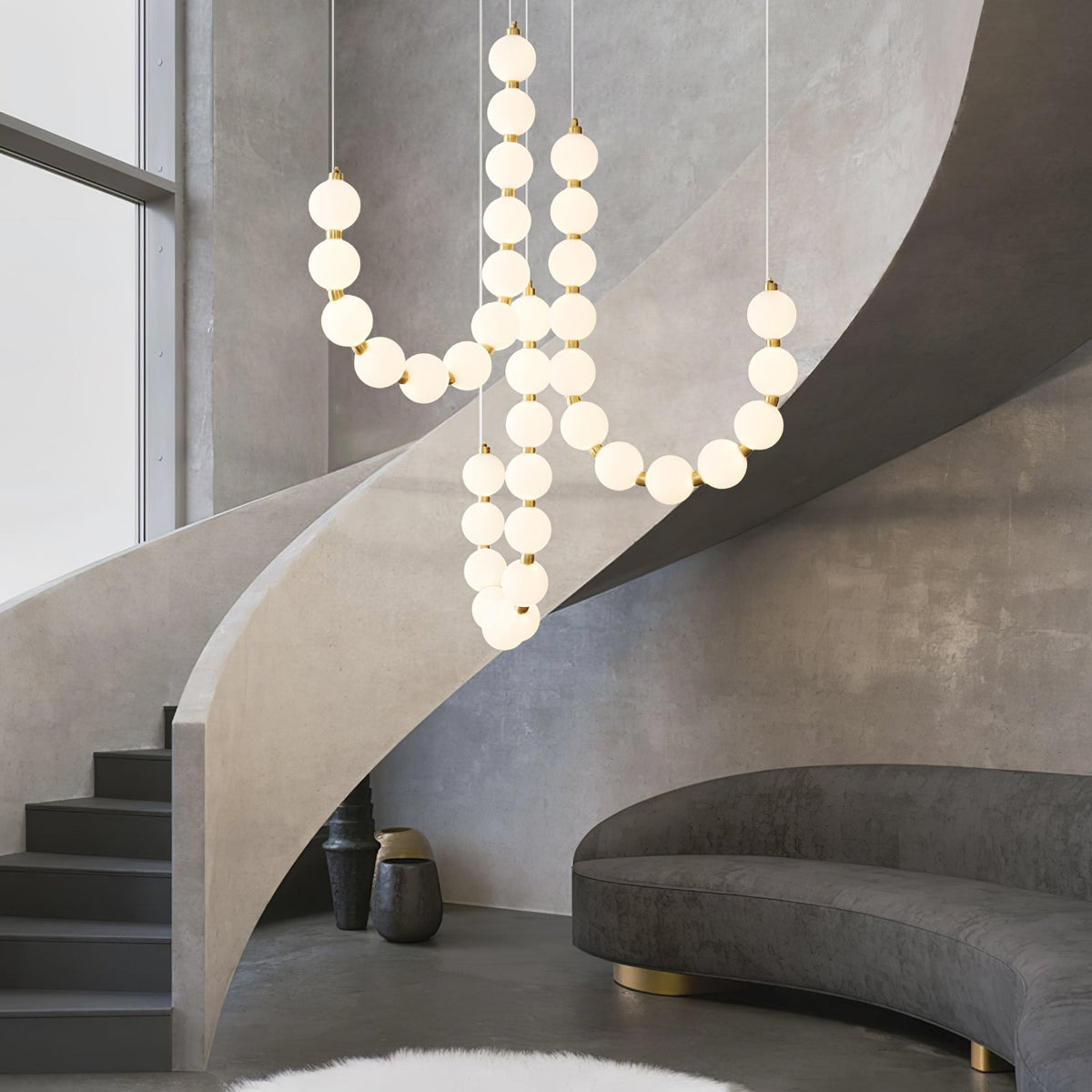modern pearl necklace chandelier with globe glass lights creating a sculptural statement in a luxury staircase interior